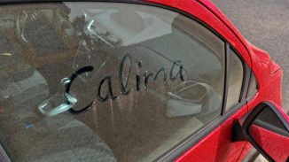 Rotes Auto mit „Calima im Staub